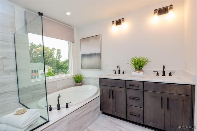 full bathroom featuring double vanity, an enclosed shower, a garden tub, and a sink