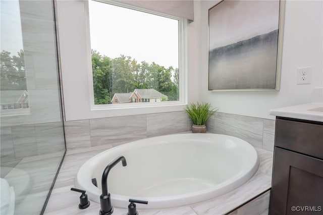 bathroom featuring a garden tub and vanity