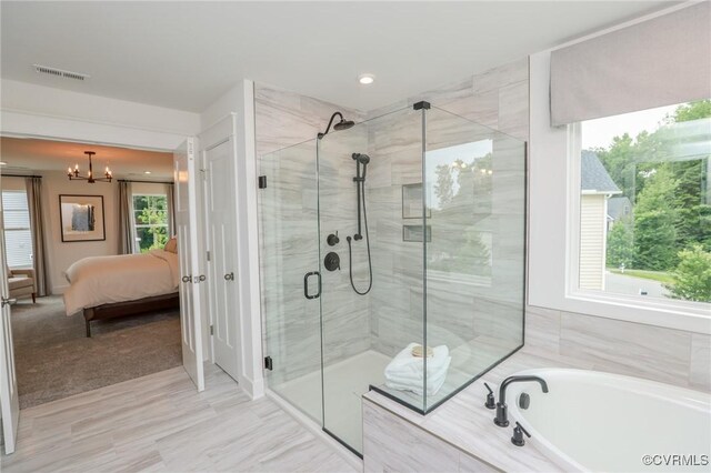 bathroom with plus walk in shower, a notable chandelier, and tile patterned floors