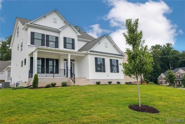 view of front of house with central AC, a front yard, and covered porch