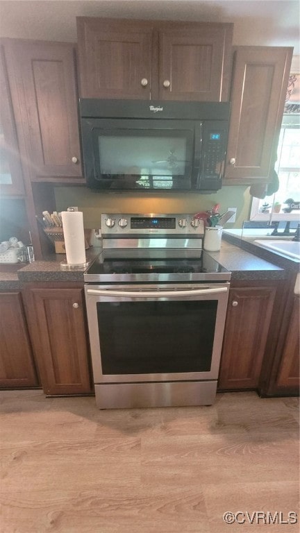 kitchen featuring light wood-type flooring, stainless steel electric range, and sink