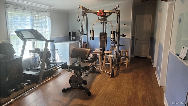 exercise area featuring crown molding and dark hardwood / wood-style floors