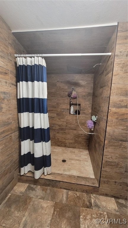 bathroom with wooden walls and a shower with curtain