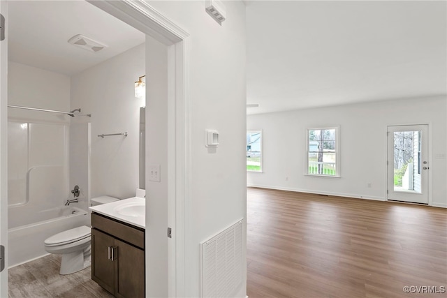 full bathroom with shower / tub combination, vanity, hardwood / wood-style floors, and toilet