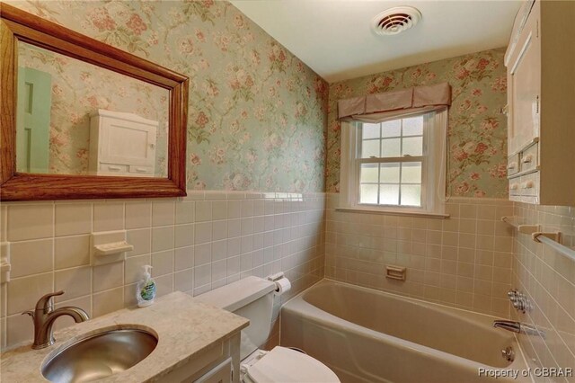 bathroom with tile walls, tasteful backsplash, vanity, and toilet