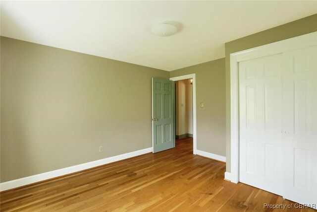 unfurnished bedroom with light hardwood / wood-style flooring and a closet