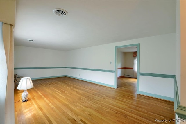 spare room with light hardwood / wood-style flooring and a baseboard heating unit