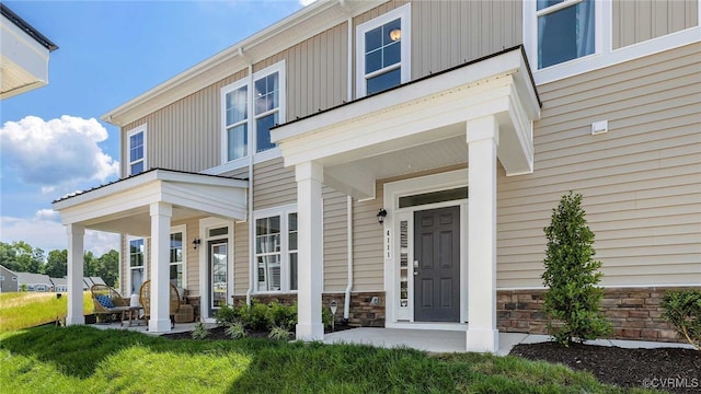 entrance to property featuring stone siding and covered porch