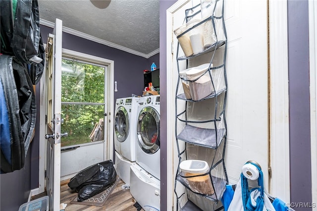 laundry area featuring hardwood / wood-style floors, a textured ceiling, washer and clothes dryer, and ornamental molding