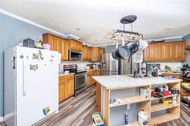 kitchen featuring hanging light fixtures, light hardwood / wood-style floors, appliances with stainless steel finishes, and ornamental molding