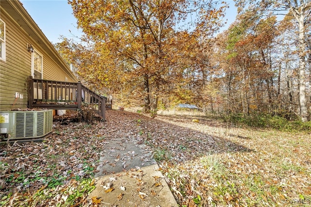 view of yard featuring central AC and a deck