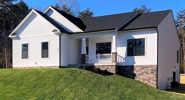 modern farmhouse style home featuring central AC unit, a front yard, and a porch