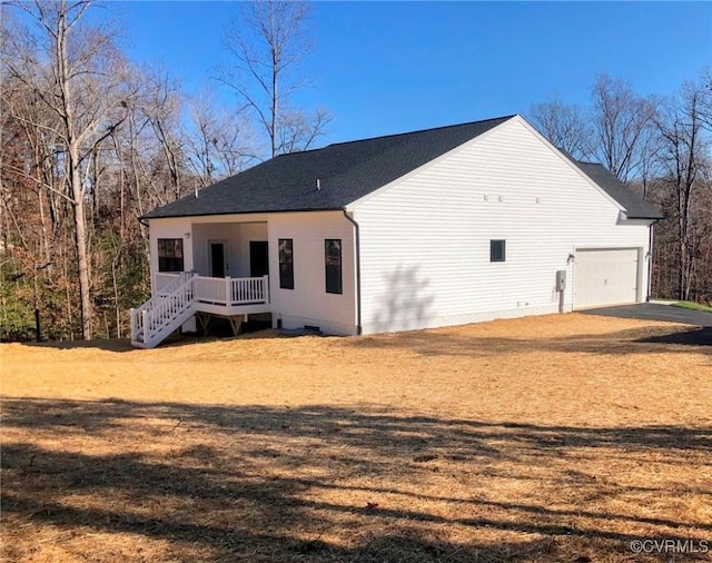 back of property featuring a garage and a lawn