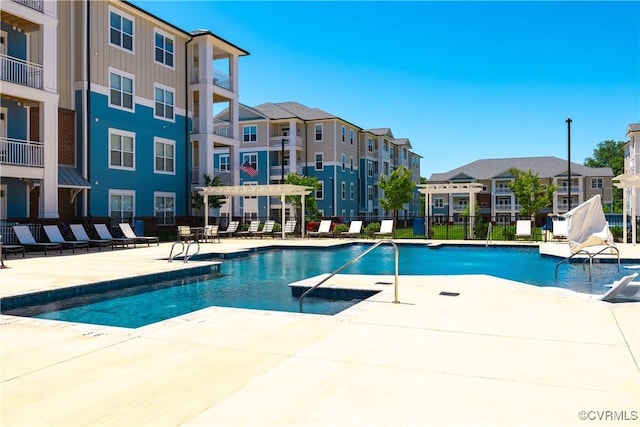 view of pool featuring a pergola, pool water feature, and a patio area