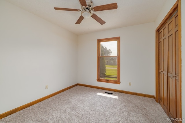 unfurnished bedroom with a closet, ceiling fan, and light carpet