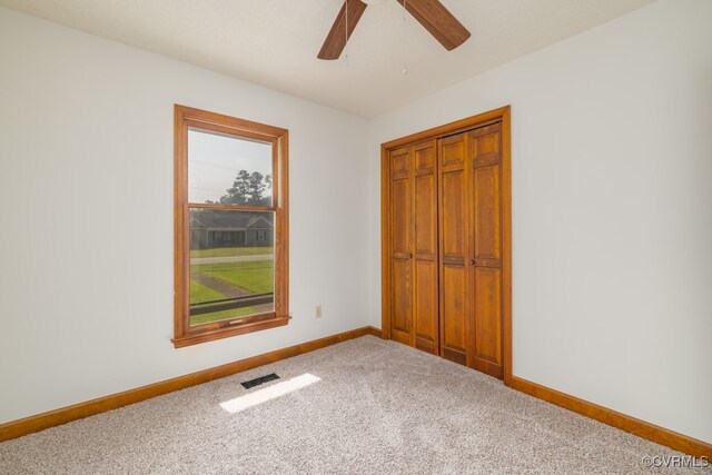 unfurnished bedroom featuring a closet, ceiling fan, and carpet