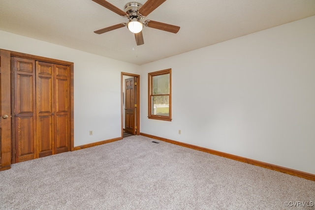 unfurnished bedroom featuring a closet, ceiling fan, and light carpet