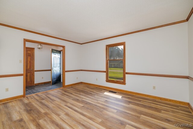 unfurnished room featuring wood-type flooring and ornamental molding