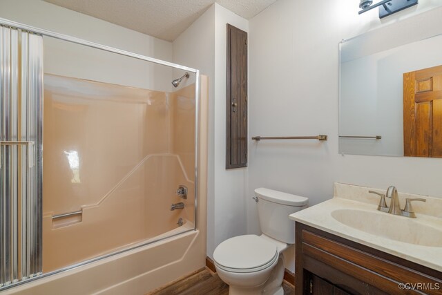 full bathroom featuring hardwood / wood-style flooring, bathtub / shower combination, toilet, vanity, and a textured ceiling