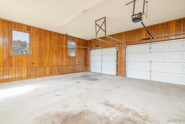 garage with a garage door opener and wooden walls