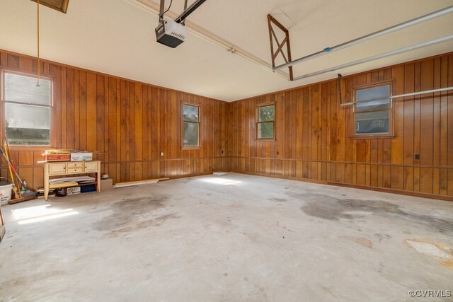 garage featuring a garage door opener and wooden walls