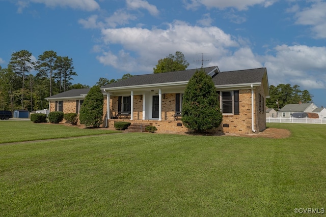 ranch-style house featuring covered porch and a front lawn