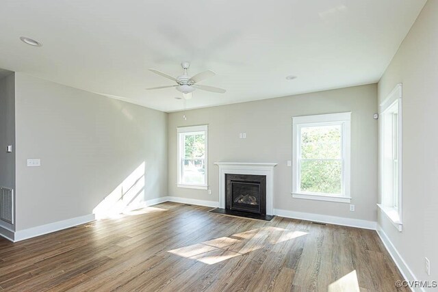 unfurnished living room with ceiling fan, a fireplace, and dark hardwood / wood-style floors