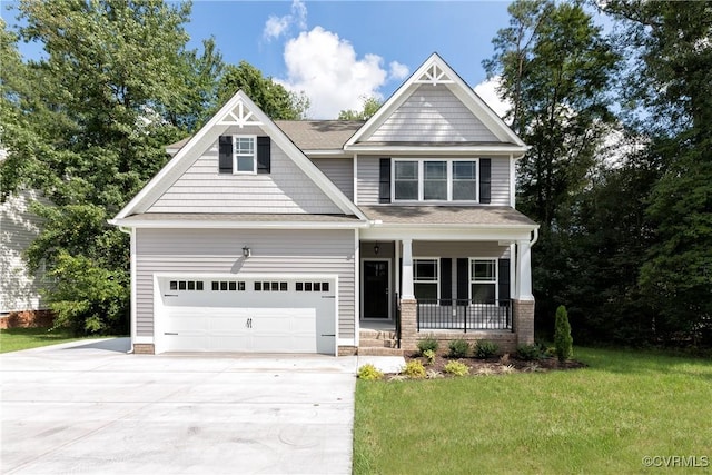 craftsman house with an attached garage, covered porch, concrete driveway, and a front lawn