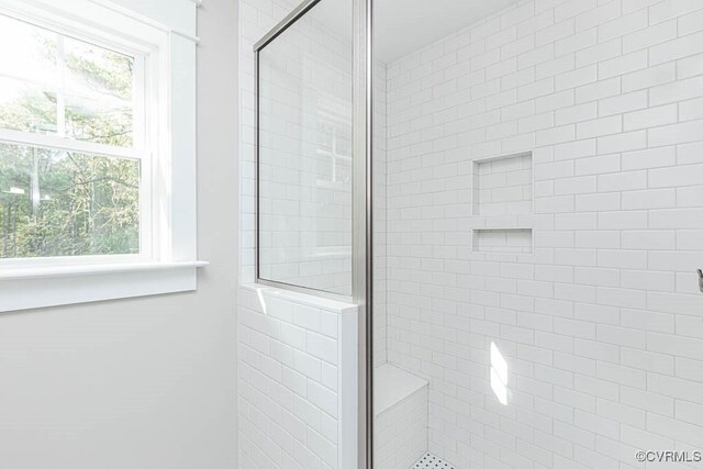 bathroom featuring a shower with shower door