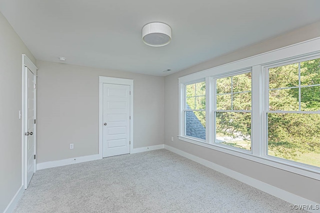 unfurnished bedroom with carpet, multiple windows, and a closet