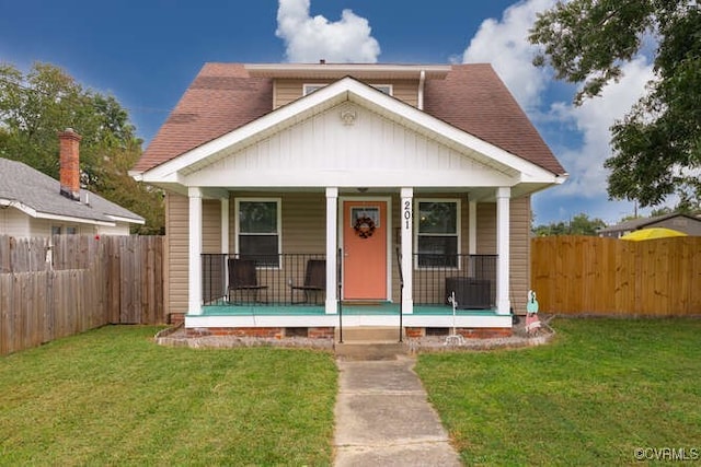 bungalow with a porch and a front lawn