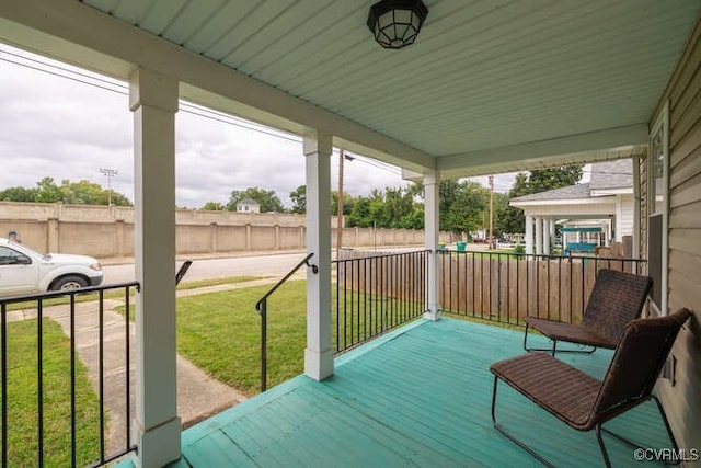 wooden terrace with a yard and covered porch