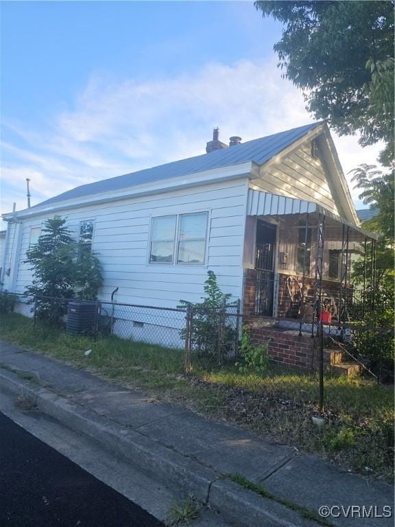 view of home's exterior featuring cooling unit and fence