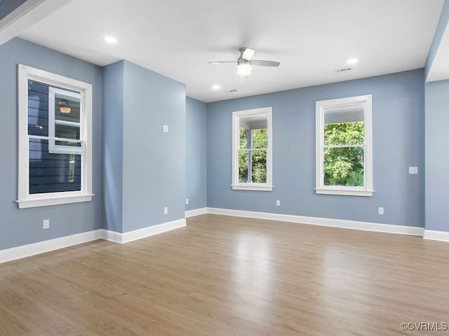 empty room with ceiling fan and light hardwood / wood-style floors