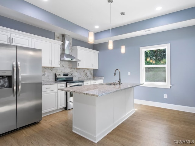 kitchen featuring wall chimney range hood, light stone countertops, stainless steel appliances, and white cabinetry