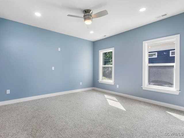 carpeted spare room featuring ceiling fan