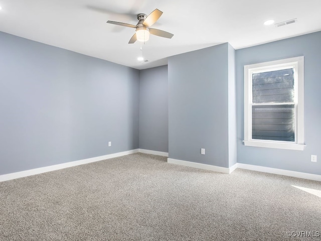 carpeted spare room featuring ceiling fan