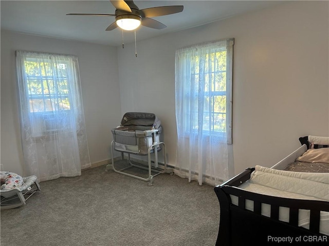 carpeted bedroom featuring multiple windows, baseboards, and ceiling fan