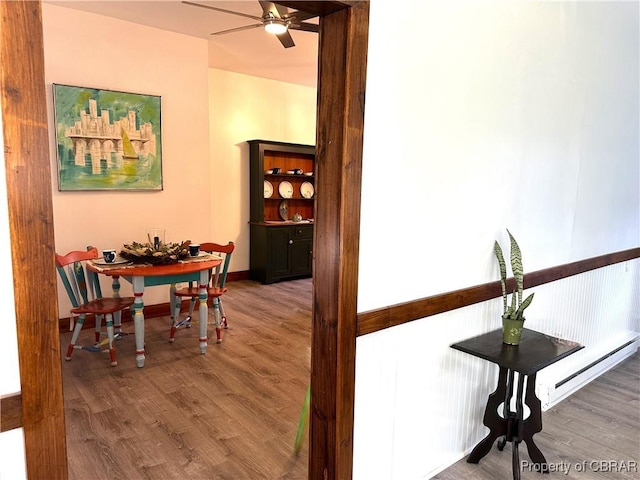 hallway featuring wood finished floors, baseboards, and a baseboard radiator