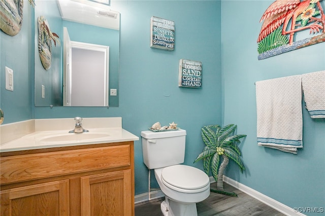 bathroom with vanity, toilet, and wood-type flooring