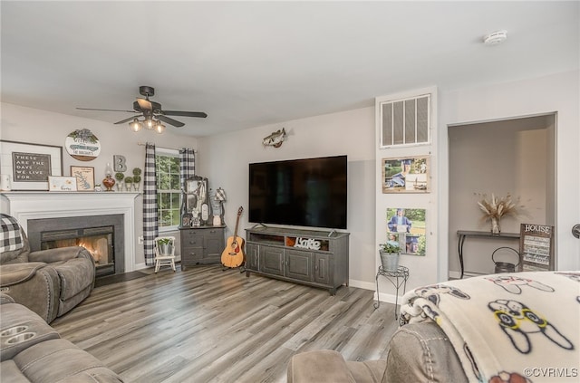 living room with ceiling fan and light hardwood / wood-style flooring