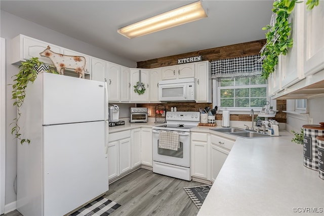 kitchen with decorative backsplash, white appliances, sink, white cabinets, and light hardwood / wood-style floors