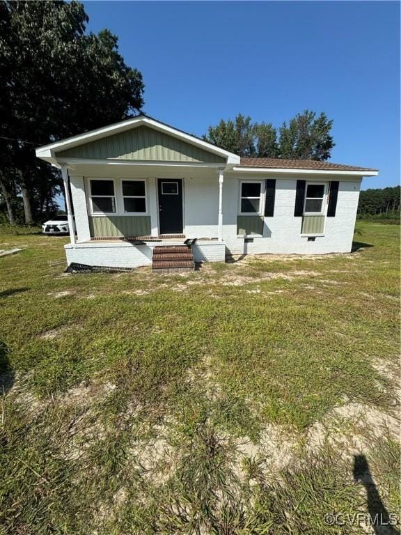 view of front of house featuring covered porch and a front lawn