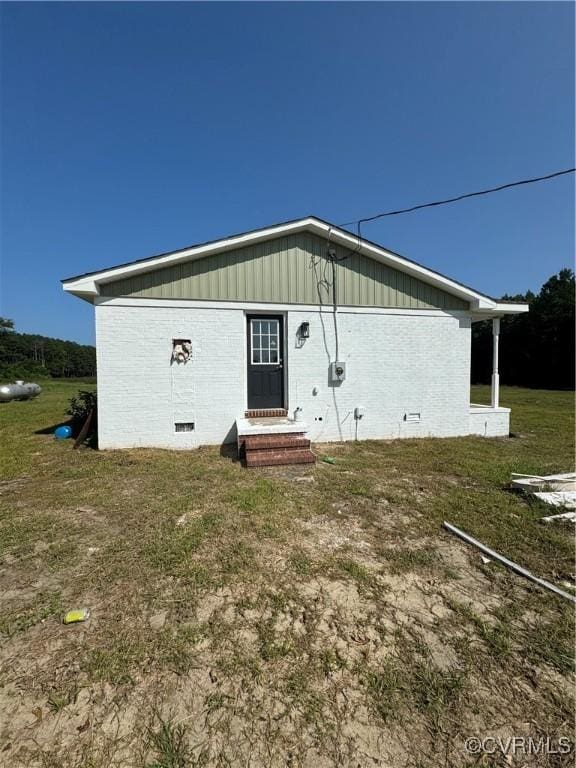 back of property featuring a lawn