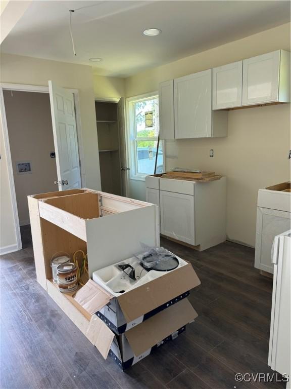 kitchen featuring white cabinets, white range oven, and dark wood-type flooring