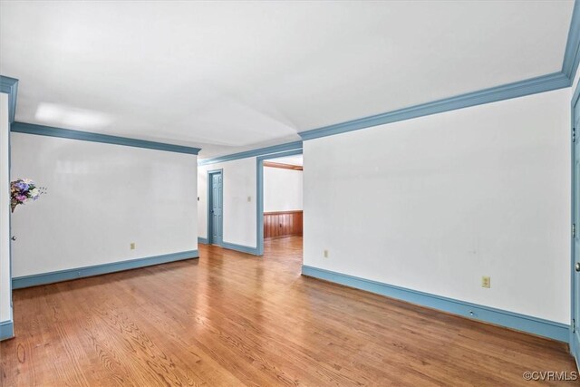 spare room with hardwood / wood-style floors and ornamental molding