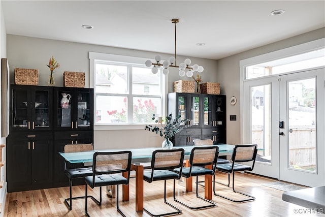 dining space with light wood-type flooring and a chandelier