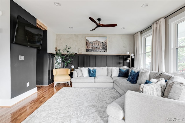 living room featuring light hardwood / wood-style flooring and ceiling fan