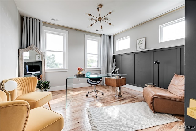 office featuring ornamental molding, a chandelier, and light hardwood / wood-style flooring