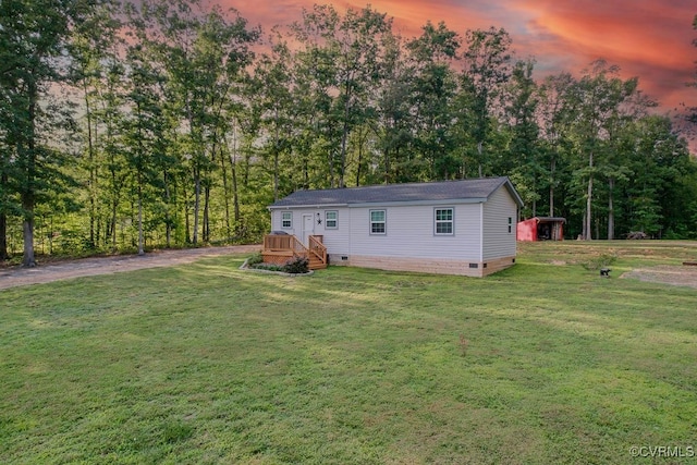 back house at dusk with a yard and an outdoor structure